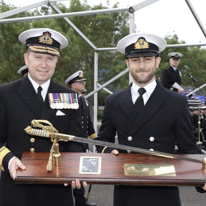 Photograph of Lt Marr receiving an award from a Rear Admiral.