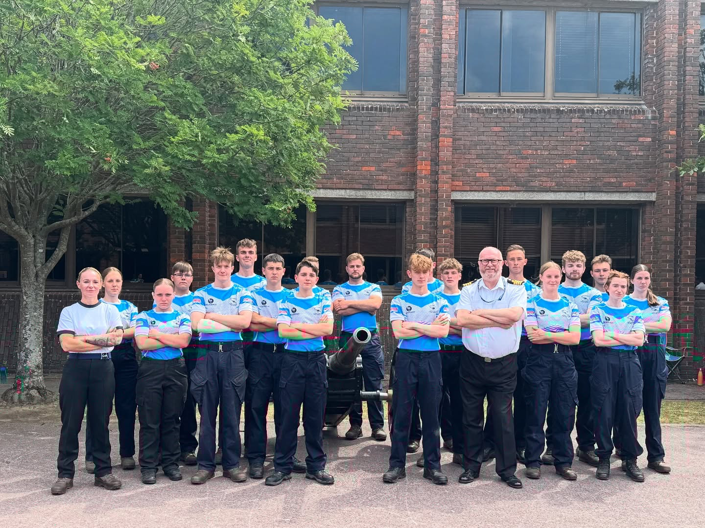 Cadets wearing team colours, pose, as a team after the Field Gun competition.