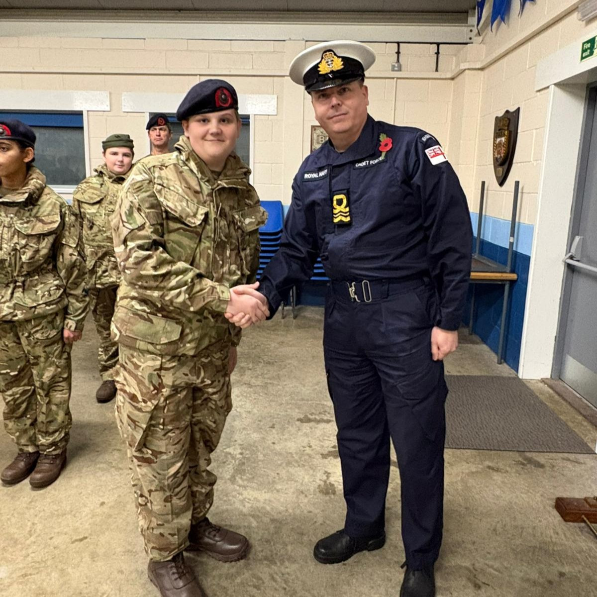 Royal Marines Cadet York shaking hands with Lieutenant Commander Janner-Burgess having received his beret as a member of the Ship's Company.