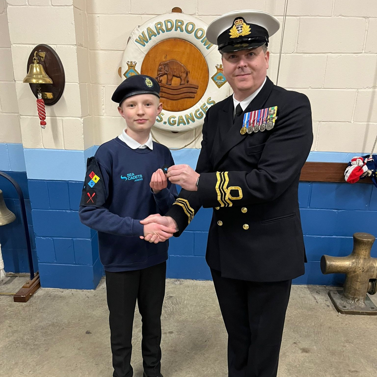 The District Officer advancing Junior Cadet First Class Burton to Able Junior Cadet.